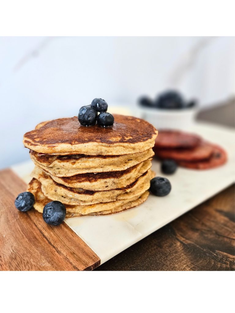 a stack of einkorn pancakes on a white marble tray with blueberries