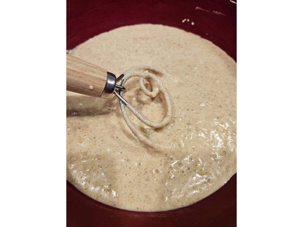einkorn pancakes batter with a dough hook in a red mixing bowl