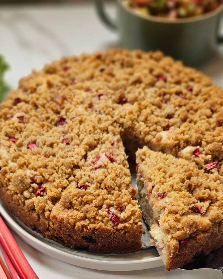 Rhubarb Sourdough Coffee Cake on a plate with fresh rhubarb on the side